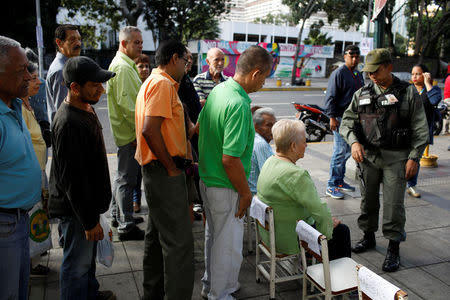 People wait in line at a polling station during a nationwide election for new mayors, in Caracas, Venezuela December 10, 2017. REUTERS/Marco Bello