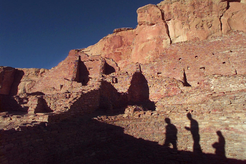 FILE - In this Nov. 21, 1996, file photo, tourists cast their shadows on the ancient Anasazi ruins of Chaco Culture National Historical Park in New Mexico. Environmentalists and Native American activists say the Biden administration's review of the federal oil and gas leasing program should result in more protections for an area of northwestern New Mexico that's considered sacred. The fight over drilling on federal land bordering Chaco Culture National Historical Park has spanned multiple presidential administrations, and an effort to update the area's management plan remains unfinished after years. (AP Photo/Eric Draper, File)