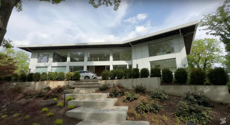 The front of a modern home with steps leading p to it