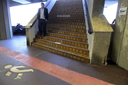 A journalist walks down the stairs which access the Fairmont Hotel where the IAAF Council hosts a news conference after a meeting to discuss the latest developments in the doping and corruption crisis that has gripped the sport over recent months, in Monaco, November 26, 2015. REUTERS/Jean-Pierre Amet