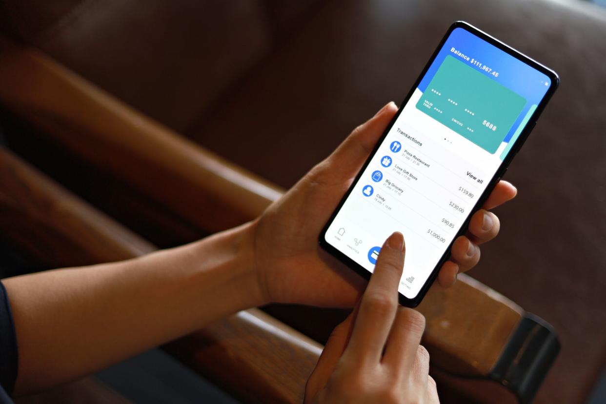 Cropped image of woman checking bank account and spending using her mobile device. Convenience and easy banking with technology.