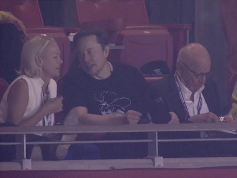 Elon Musk sits between Elisabeth Murdoch and Rupert Murdoch.