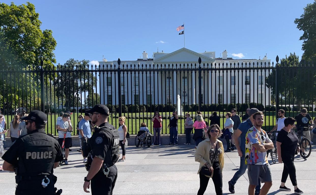 Police officers and tourists stand outside the White House on Sept. 26, 2021 in Washington, D.C.