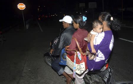 Residents ride a motorcycle to higher ground after an earthquake struck off the west coast of Sumatra in the city of Padang, West Sumatra, Indonesia March 2, 2016. REUTERS/Iggoy el Fitra/Antara Foto