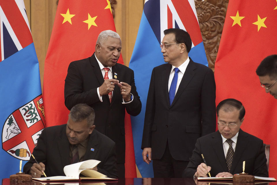 FILE - Fiji's Prime Minister Prime Minister Frank Bainimarama, top left, talks with Chinese Premier Li Keqiang, top right, during a signing ceremony between the two countries at the Great Hall of the People in Beijing Tuesday, May 16, 2017. China wants 10 small Pacific nations to endorse a sweeping agreement covering everything from security to fisheries in what one leader warns is a “game-changing” bid by Beijing to wrest control of the region. (Nicolas Asfouri/Pool Photo via AP, File)