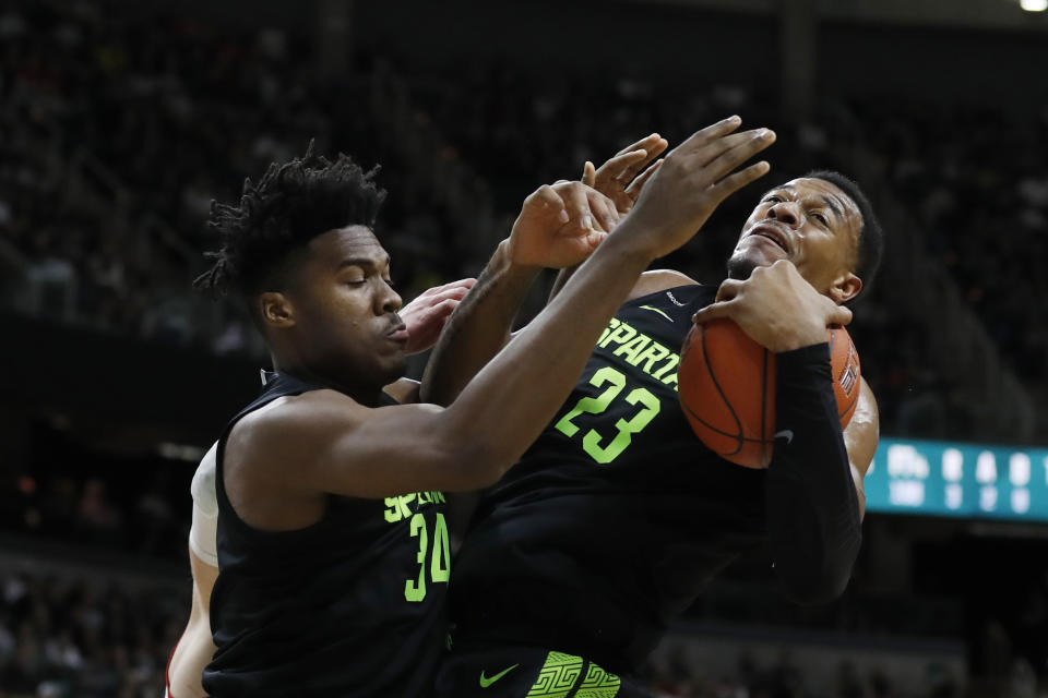 Michigan State forward Xavier Tillman (23) grabs a rebound next to teammate Julius Marble (34) during the first half of an NCAA college basketball game against Wisconsin, Friday, Jan. 17, 2020, in East Lansing, Mich. (AP Photo/Carlos Osorio)