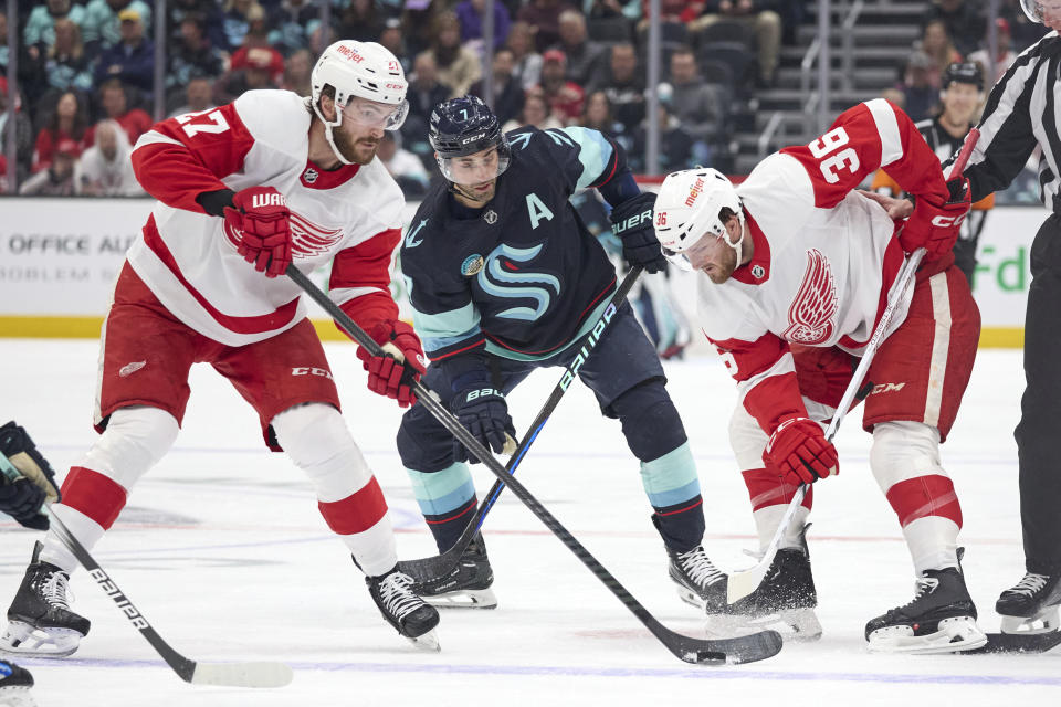 Detroit Red Wings center Michael Rasmussen, left, passes the puck with right wing Christian Fischer (36) defending ,during the first period of an NHL hockey game, Monday, Feb. 19, 2024, in Seattle. (AP Photo/John Froschauer)