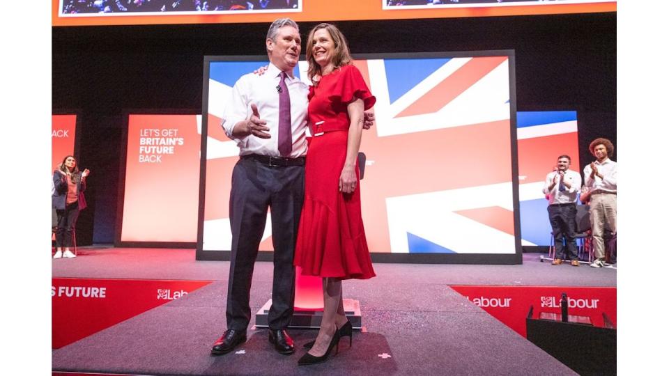 Victoria and Keir Starmer smiling in front of a union jack flag