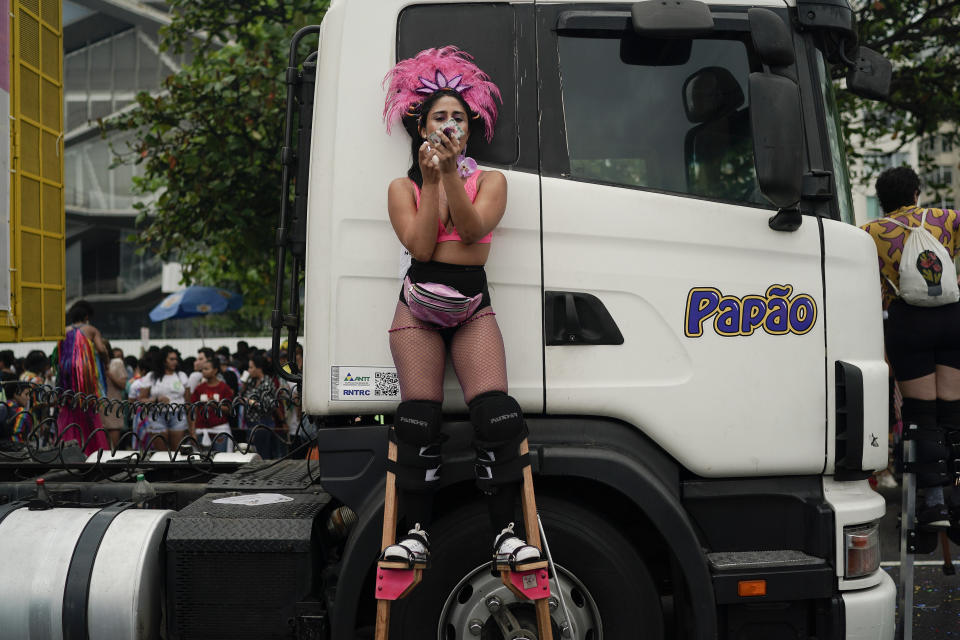 A woman on stilts retouches her makeup during the annual gay pride parade along Copacabana beach in Rio de Janeiro, Brazil, Sunday, Sept. 22, 2019. The 24th gay pride event titled this year's parade: "For democracy, freedom and rights, yesterday, today and forever." (AP Photo/Leo Correa)