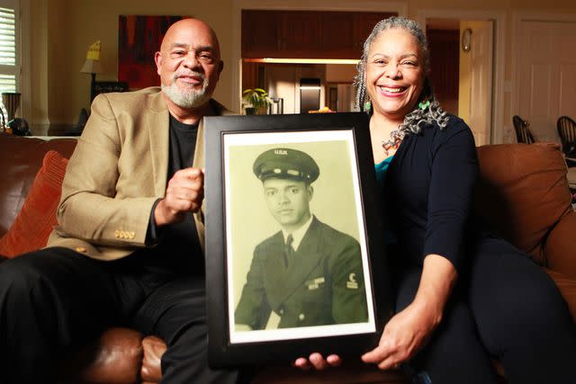 <p>National Geographic/Nelson Adeosun</p> Frank Bland (left) and his wife, Irene Bland, hold a portrait of Frank's father, George Bland, who served as mess attendant on the USS West Virginia and is spotlighted in 'Erased: WW2's Heroes of Color'