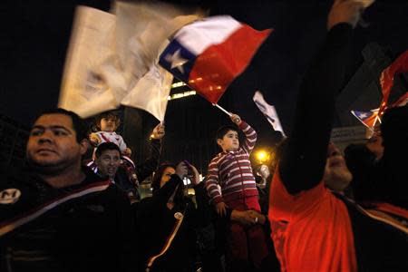 Supporters of Chilean presidential candidate Michelle Bachelet wave signs and flags after the first round of presidential election in Santiago, November 17, 2013. REUTERS/Carlos Vera