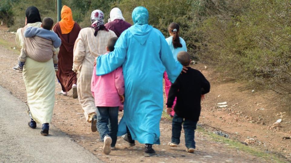 Mujeres y niños caminando