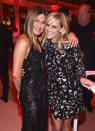 <p>Hollywood powerhouses Reese Witherspoon, in Michael Kors, and Jennifer Aniston, in Versace, share a hug. (Photo: Getty Images) </p>