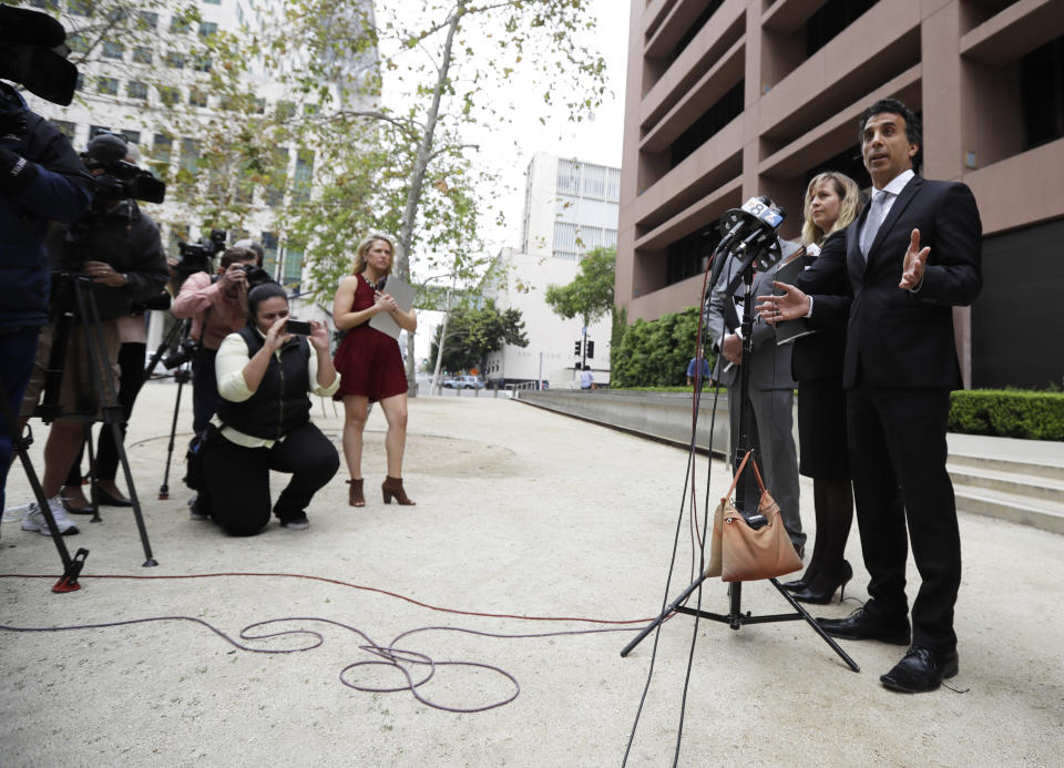Plaintiff attorney Jason Forge, right, speaks alongside attorney Rachel Jensen, second from right, after a hearing for a lawsuit against President Donald Trump Thursday, March 30, 2017, in San Diego. A judge said Thursday he will issue a ruling at a later time on whether to accept an agreement for President Trump to pay $25 million to settle lawsuits over his now-defunct Trump University. (AP Photo/Gregory Bull)