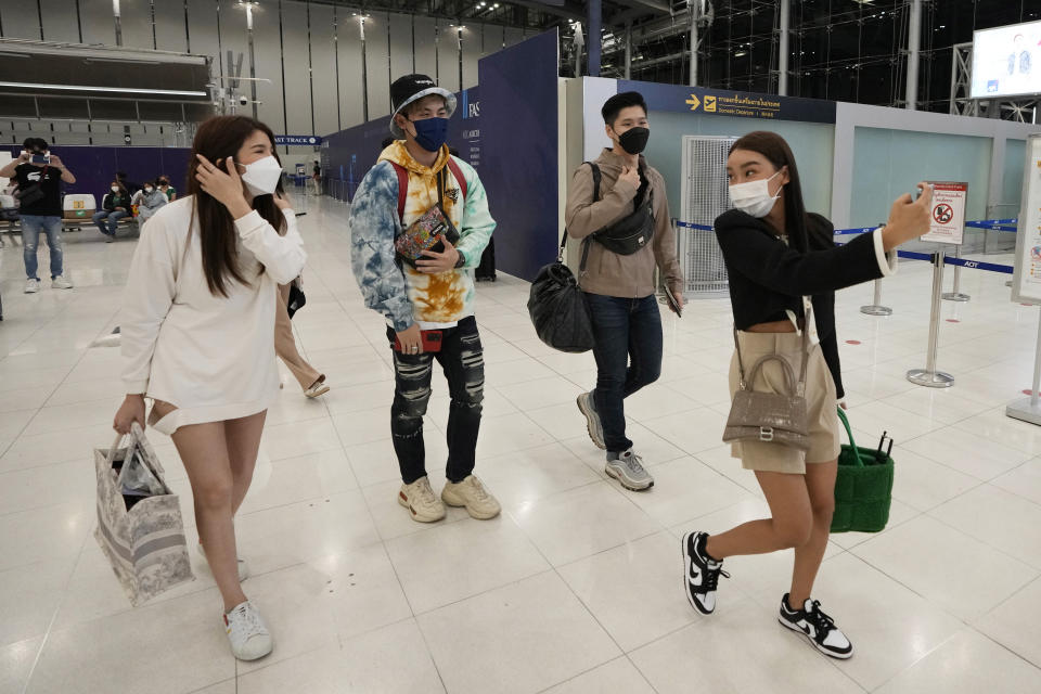 FILE - Thai travelers Korranut Nuntanatamon, front, takes selfies with Tidarat Margsree, from left, Sorrasek Thuantawee and Kantpong Madeecharoenporn after check-in for their trip to Osaka and Tokyo, at Suvarnabhumi International Airport in Samut Prakarn province, Thailand, on June 23, 2022. Individual travelers will be able to visit Japan without visas beginning Tuesday, Oct. 11, just like in pre-COVID-19 times. (AP Photo/Sakchai Lalit, File)