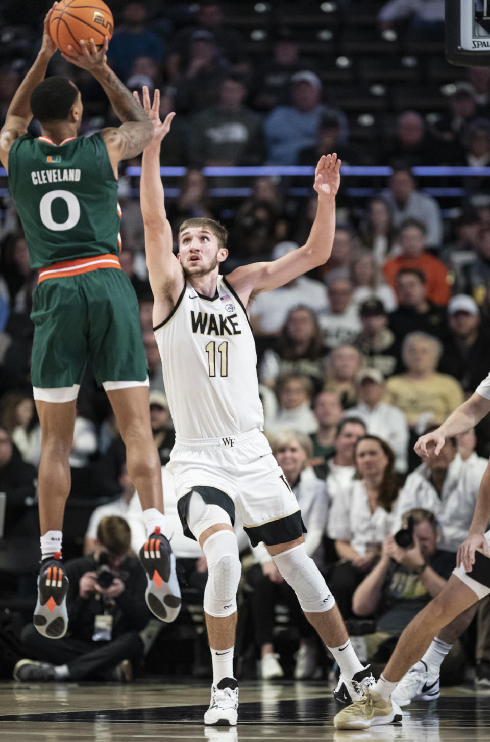 Miami guard Matthew Cleveland (0) shoots over Wake Forest forward Andrew Carr (11) in the first half of an NCAA college basketball game Saturday, Jan. 6, 2024, in Winston-Salem, N.C. (Allison Lee Isley/The Winston-Salem Journal via AP)