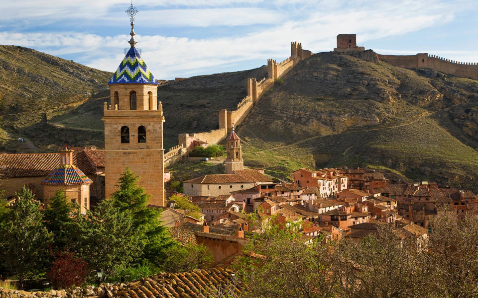 <p>A sliver of medieval Spain has been preserved within the fortified walls of this village, which is surrounded by the barren hills of the central Aragon region. Down Albarrac?n's narrow alleys and winding lanes await ancient stone towers and ocher-hued castles and chapels. Towering above it all is a cathedral built in the region's typical Mudejar style with ornamental detailing rooted in Islamic art.</p>