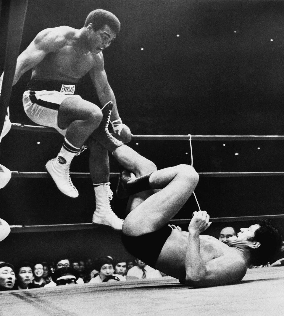 CORRECTS TO 1976, NOT 1979 - FILE - World heavyweight boxing champion Muhammad Ali is shown trying to evade kicks by wrestler Antonio Inoki during their 15-round World Martial Arts match on July 26, 1976, in Tokyo. A popular Japanese professional wrestler and lawmaker Antonio Inoki, who faced a world boxing champion Muhammad Ali in a mixed martial arts match in 1976, has died at 79. The New Japan Pro-Wrestling Co. says Inoki, who was battling an illness, died earlier Saturday, Oct. 1, 2022. (AP Photo, File)