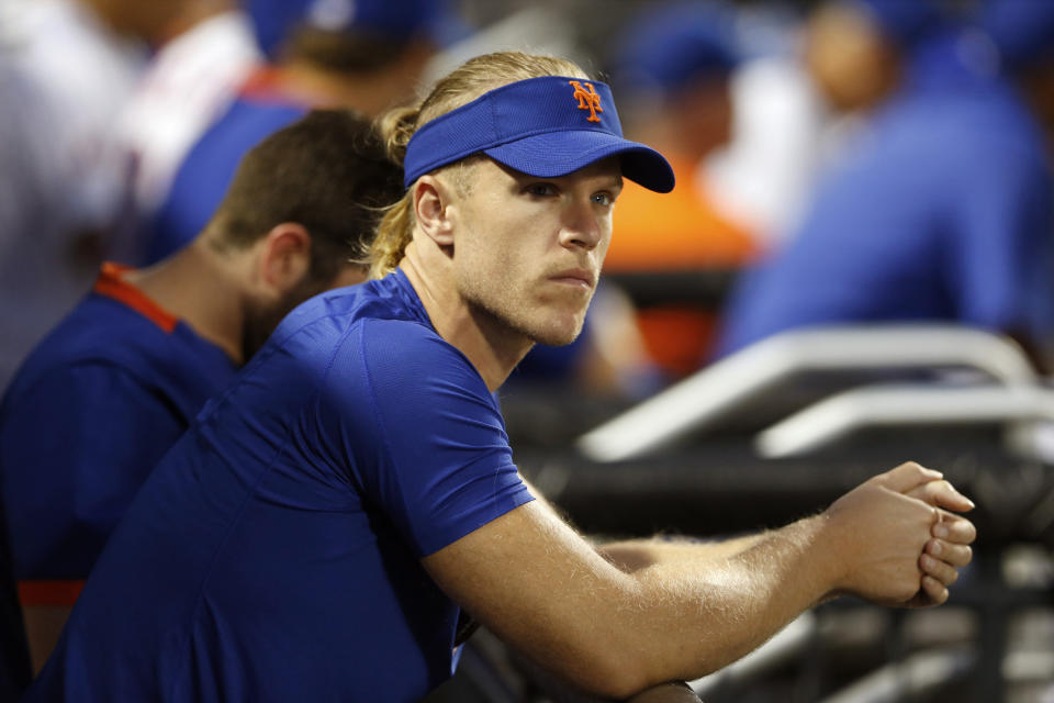 FILE - In this Aug. 14, 2021, file photo, New York Mets pitcher Noah Syndergaard watches play against the Los Angeles Dodgers during the first inning of a baseball game in New York. A person familiar with the situation tells The Associated Press that Syndergaard has tested positive for COVID-19. Syndergaard was scratched from a rehab start on Sunday, Aug. 29, 2021. The person spoke on condition of anonymity because the team has not disclosed the positive test. (AP Photo/Noah K. Murray, File)