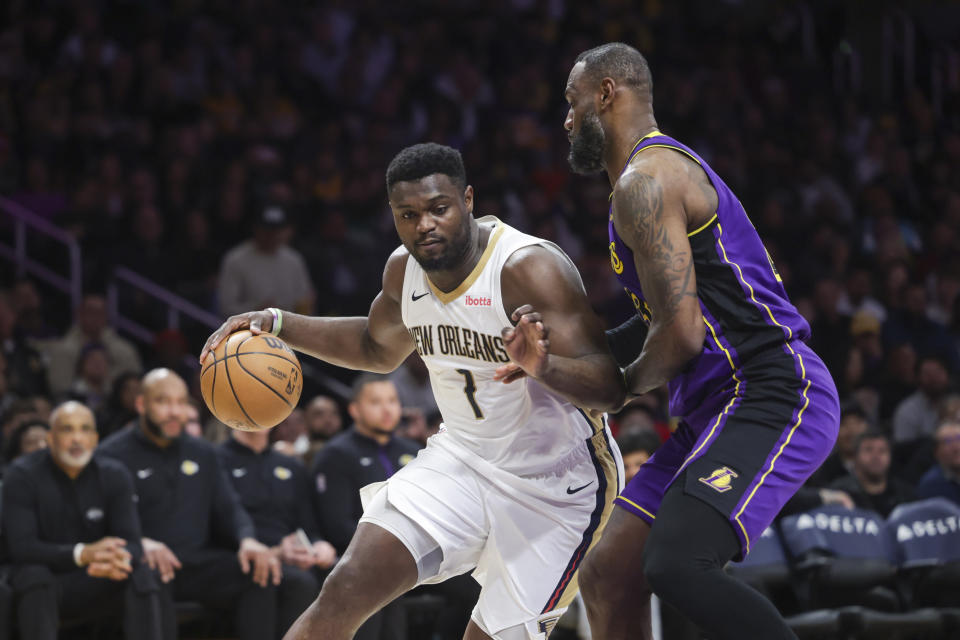 New Orleans Pelicans forward Zion Williamson (1) dribbles the ball as Los Angeles Lakers forward LeBron James defends during the first half of an NBA basketball game Friday, Feb. 9, 2024, in Los Angeles. (AP Photo/Yannick Peterhans)