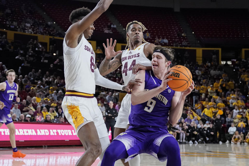 Washington guard Paul Mulcahy (9) gets double-teamed by Arizona State forward Alonzo Gaffney (8) and Arizona State guard Adam Miller (44) during the first half of an NCAA college basketball game Thursday, Feb. 22, 2024, in Tempe, Ariz. (AP Photo/Darryl Webb)