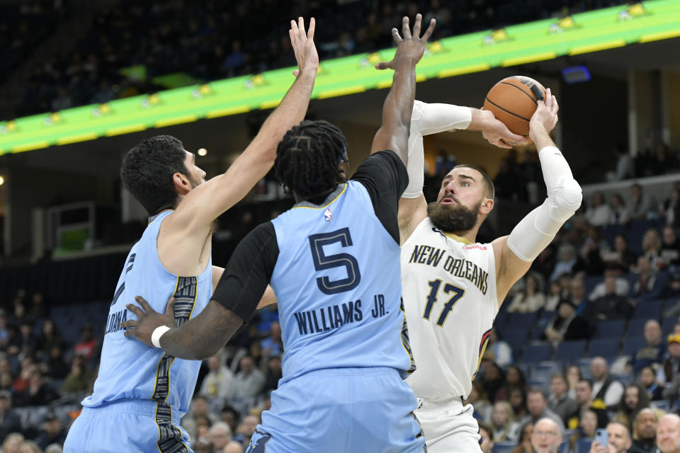 New Orleans Pelicans center Jonas Valanciunas (17) handles the ball against Memphis Grizzlies forward Santi Aldama and guard Vince Williams Jr. (5) in the first half of an NBA basketball game, Monday, Feb. 12, 2024, in Memphis, Tenn. (AP Photo/Brandon Dill)