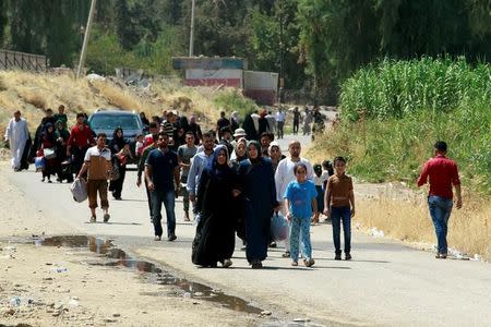 Iraqis walk towards the floating bridge between east and west of Mosul, Iraq, July 21, 2017. REUTERS/Khalid Al-Mousily