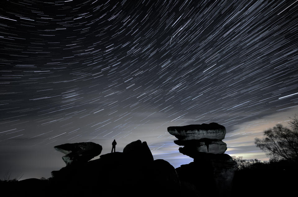A man watches a meteor during the Geminid meteor shower over Brimham Rocks in North Yorkshire. (Getty Images)