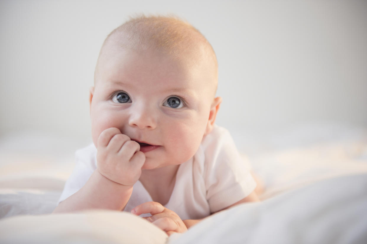 Newborn baby lying on his stomach to illustrate a banned baby name list