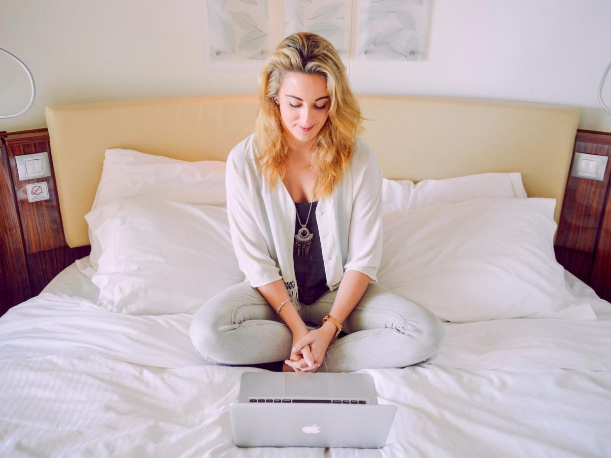 woman laptop macbook bed smiling