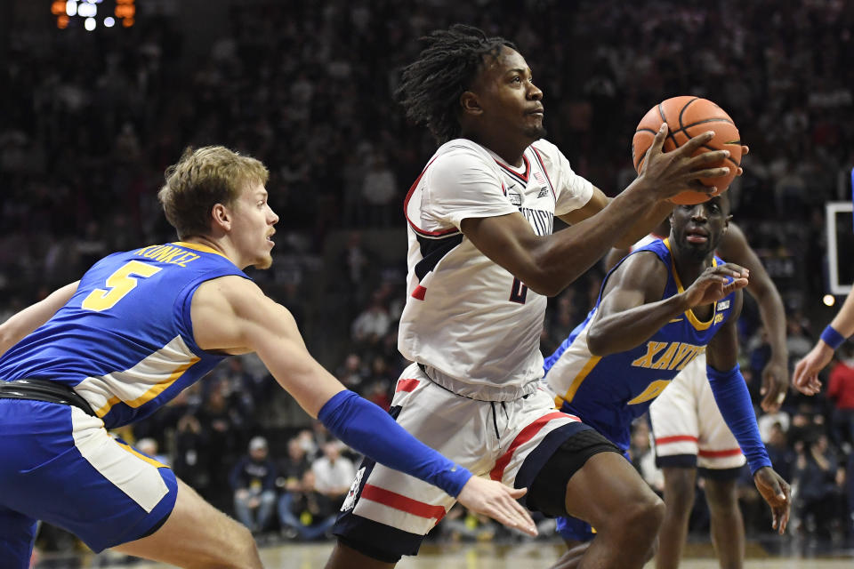 UConn's Tristen Newton drives past Xavier's Adam Kunkel, left, and Souley Boum, right, in the first half of an NCAA college basketball game, Wednesday, Jan. 25, 2023, in Storrs, Conn. (AP Photo/Jessica Hill)