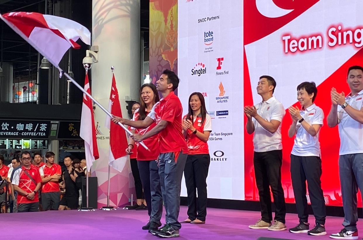 Squash player Samuel Kang, flag bearer for Team Singapore for the upcoming SEA Games, holds aloft the Singapore flag at the flag presentation ceremony at Our Tampines Hub. (PHOTO: Chia Han Keong/Yahoo News Singapore)