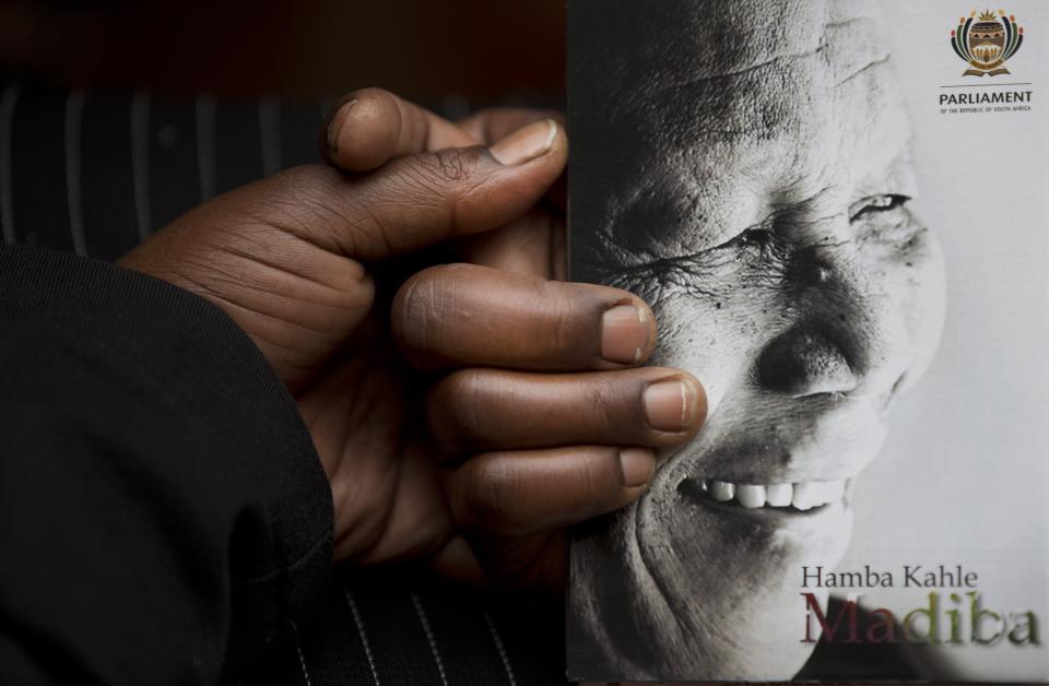 A man holds the official programme ahead of the memorial service for former South African president Nelson Mandela at the FNB Stadium in the Johannesburg, South Africa township of Soweto, Tuesday, Dec. 10, 2013. (AP Photo/Peter Dejong)