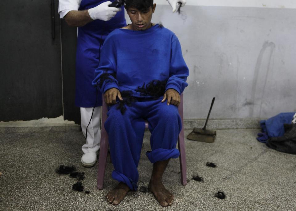 In this May 29, 2013 photo, a patient gets his hair cut by a nurse at the Neuro-Psychiatric Hospital in Asuncion, Paraguay. Paraguay's only public psychiatric hospital is forced to feed hundreds of patients with donated food for lack of funding. Meanwhile, public health services are nearly collapsing. (AP Photo/Jorge Saenz)