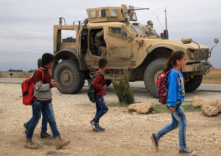 FILE PHOTO: Syrian schoolchildren walk as U.S. troops patrol near Turkish border in Hasakah, Syria November 4, 2018. REUTERS/Rodi Said