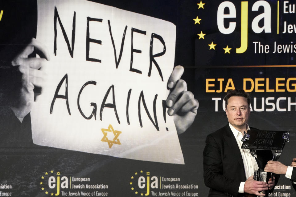 Tesla and SpaceX's CEO Elon Musk holds an artwork received from EJA Chairman Rabbi Menachem Margolin at the European Jewish Association's conference, in Krakow, Poland, Monday, Jan. 22, 2024. Musk visited earlier in the day the site of the Auschwitz-Birkenau Nazi German death camp in Oswiecim, Poland, the private visit apparently took place in response to calls from some Jewish religious leaders for Musk to see with his own eyes the most symbolic site of the horrors of the Holocaust. (AP Photo/Czarek Sokolowski)