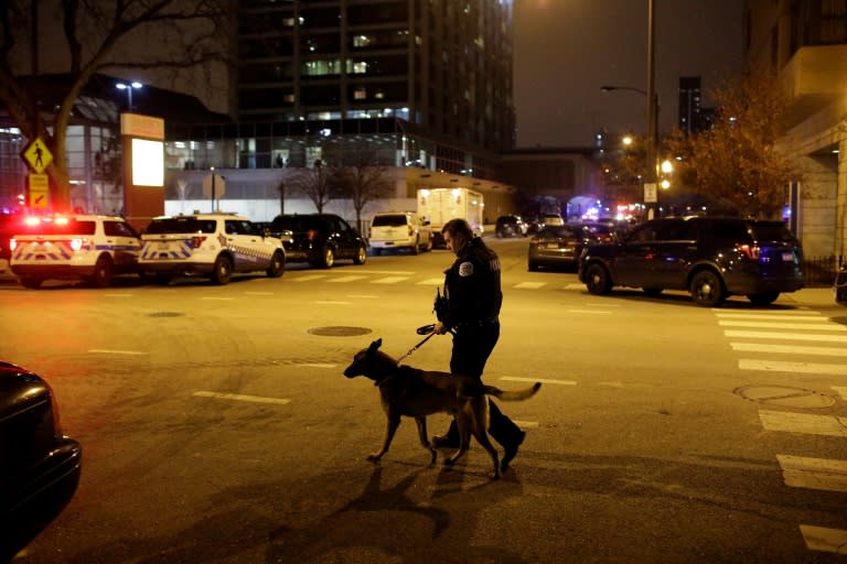 A Chicago police officer walks with his dog outside Mercy Hospital where an argument in the parking lot escalated into a shooting that left three dead