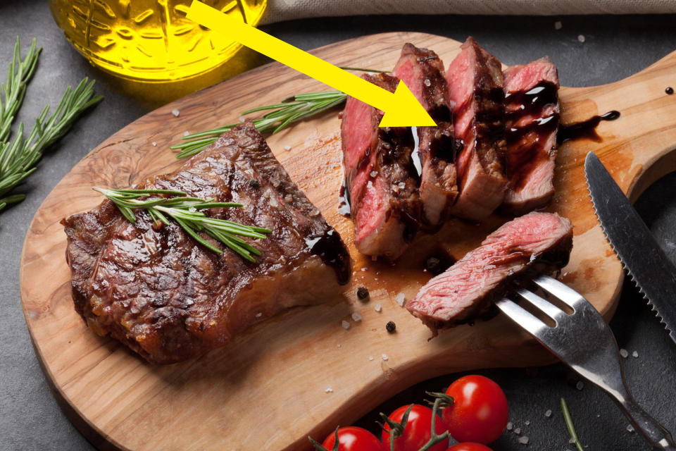 Grilled sliced beef steak on cutting board drizzled with balsamic.