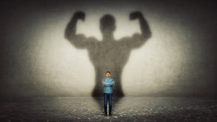 A man's muscular shadow on a wall