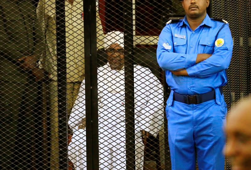 Sudanese former president Omar Hassan al-Bashir sits inside a cage during the hearing of the verdict that convicted him of corruption charges in a court in Khartoum