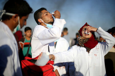 FILE PHOTO - Female Palestinian medic Razan Al-Najar reacts to tear gas as she works at the scene of clashes at Israel-Gaza border, in the southern Gaza Strip April 1, 2018. REUTERS/Ibraheem Abu Mustafa/File Photo