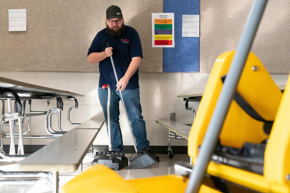 The satisfaction of cleaning up messes is an endeavor that Austin Smith, head custodian at Berryton Elementary School, takes with pride as he sweeps and mops the floor following breakfast Feb. 21.