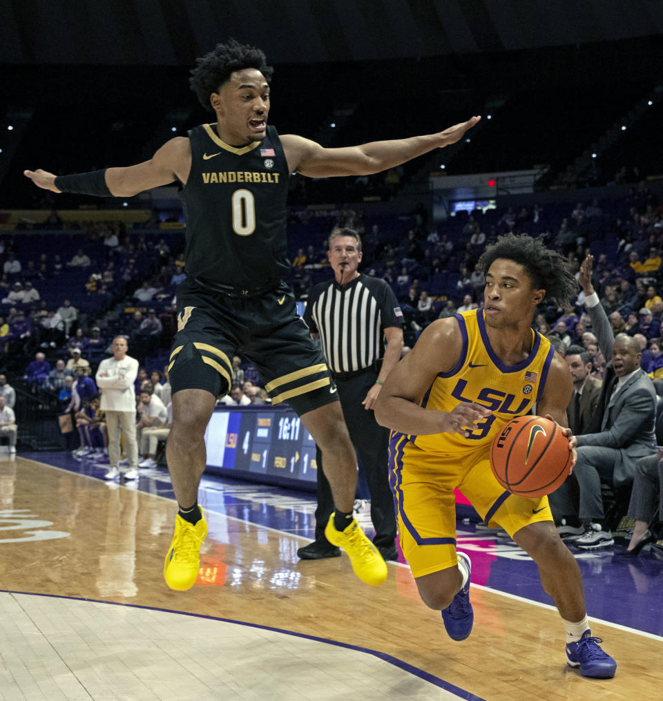 Vanderbilt guard Tyrin Lawrence (0) goes airborne on the defensive against LSU guard Jalen Cook (3) during an NCAA college basketball game, Tuesday, Jan. 9, 2024 in Baton Rouge, La. (Hilary Scheinuk/The Advocate via AP)