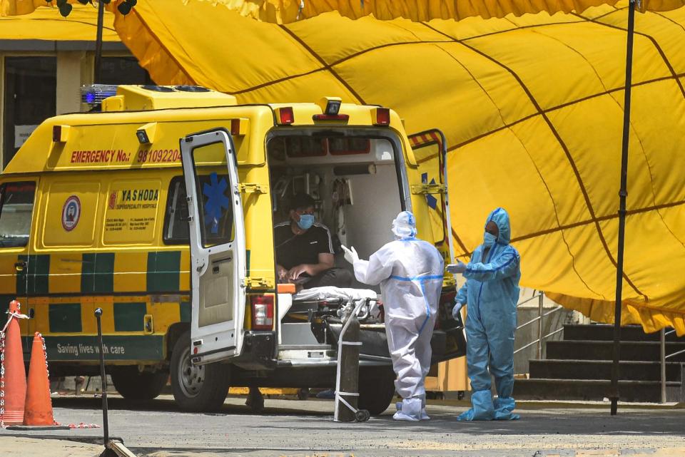 Health workers wearing Personal protection suits shift a COVID-19 infected person from an ambulance into the Gangaram Hospital on June 11, 2020 in New Delhi, India. (Photo by Sanchit Khanna/Hindustan Times via Getty Images)