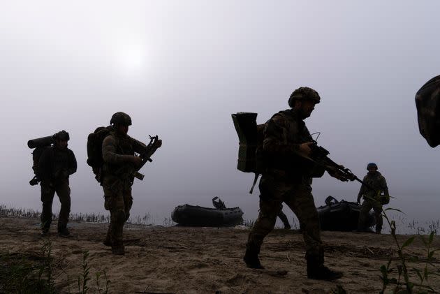 Ukrainian servicemen walk on the shore of Dnipro river 