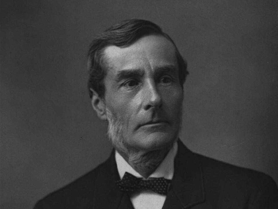 A black and white photo of a man in a suit and bowtie looking off to the right.