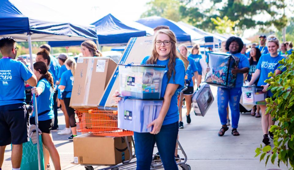 University of Arkansas at Fort Smith student volunteers carry first-year students’ belongings to the Lion's Den Residence Hall during the university’s annual move in weekend in 2019.