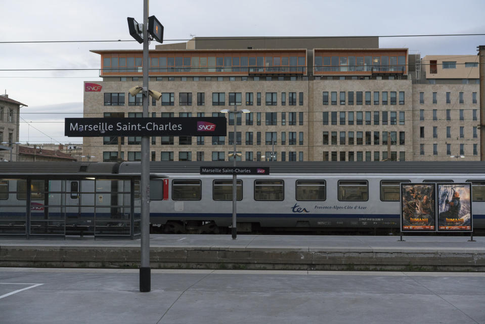 A stationary train parked at the Gare St-Charles station in Marseille, southern France, as services wind-down Wednesday, Dec. 4, 2019. France is getting ready for massive, nationwide strikes from Thursday against government plans to overhaul the state pension system that will disrupt trains, buses and flights and force many schools to close. (AP Photo/Daniel Cole)