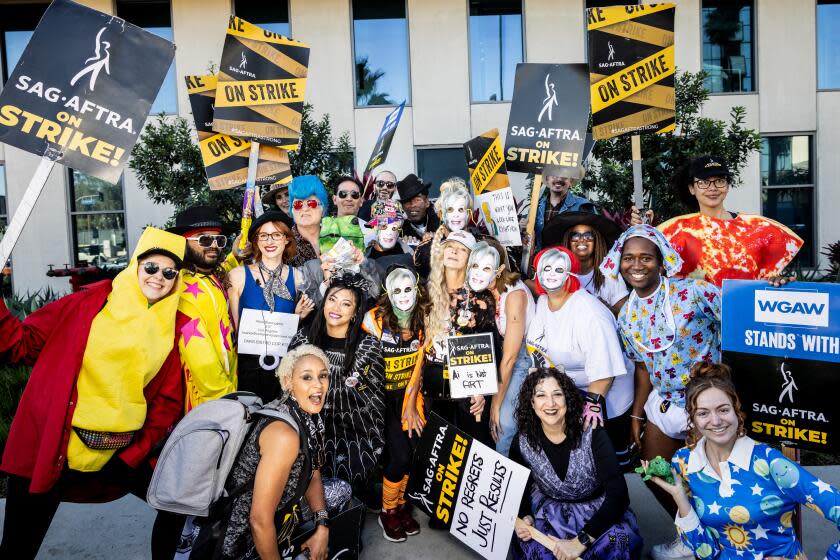 Los Angeles, CA - October 31: Frances Fisher, a member of the SAG-AFTRA negotiating team, center with no mask and a sign with the words, "Ai is not art," poses with supporters walking the Halloween line during the SAG-AFTRA picket, in front of Netflix in Los Angeles, CA, Tuesday, Oct. 31, 2023. (Jay L. Clendenin / Los Angeles Times)