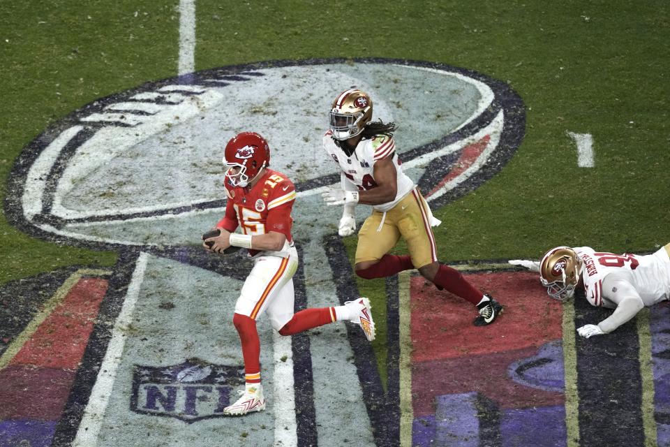 Patrick Mahomes (15), quarterback de los Chiefs de Kansas City, corre escapando de Fred Warner, de los 49ers de San Francisco, durante el tiempo extra del Super Bowl 58, el domingo 11 de febrero de 2024, en Las Vegas. (AP Foto/Charlie Riedel)